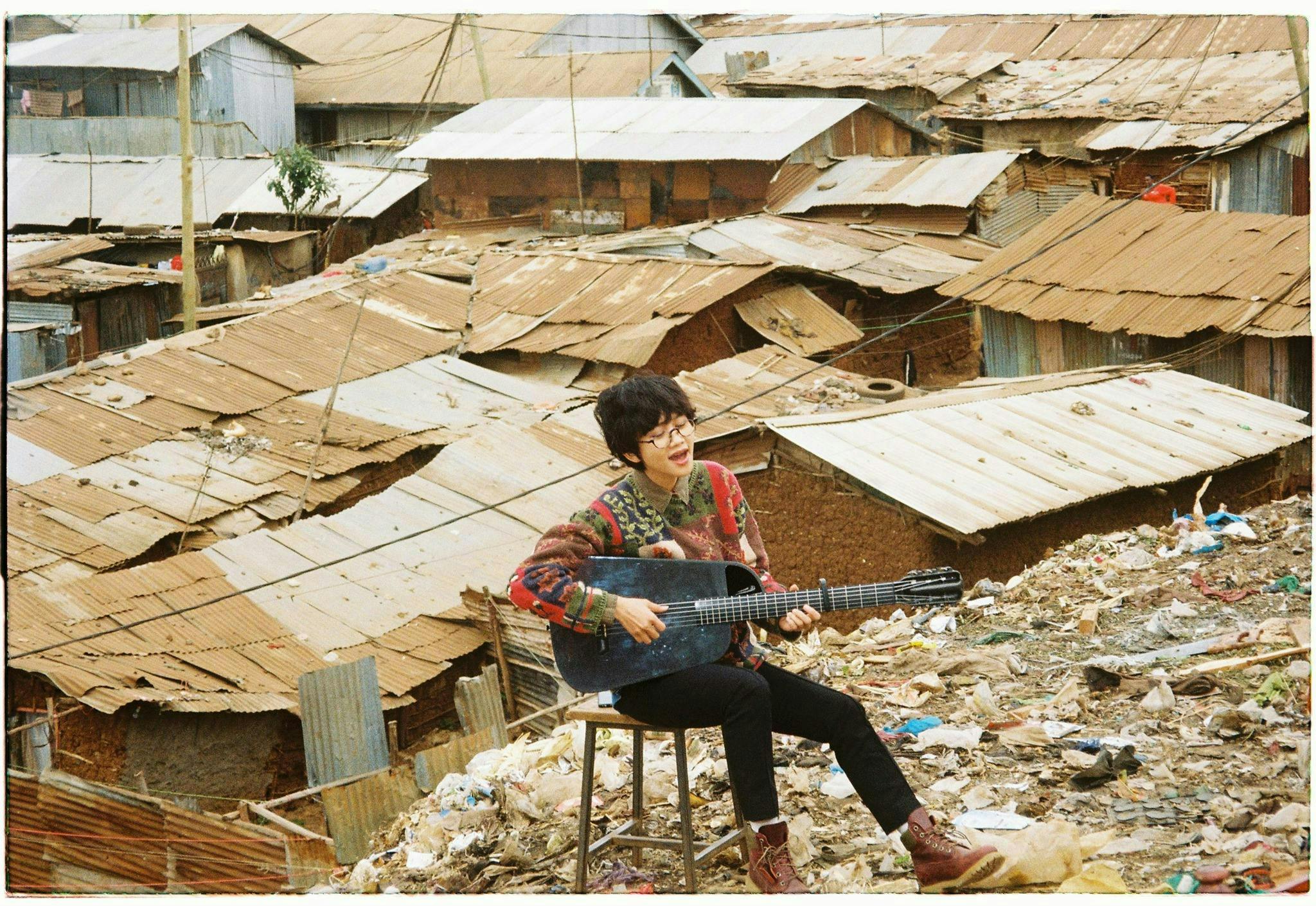 slum urban building person guitar musical instrument leisure activities shoe clothing footwear
