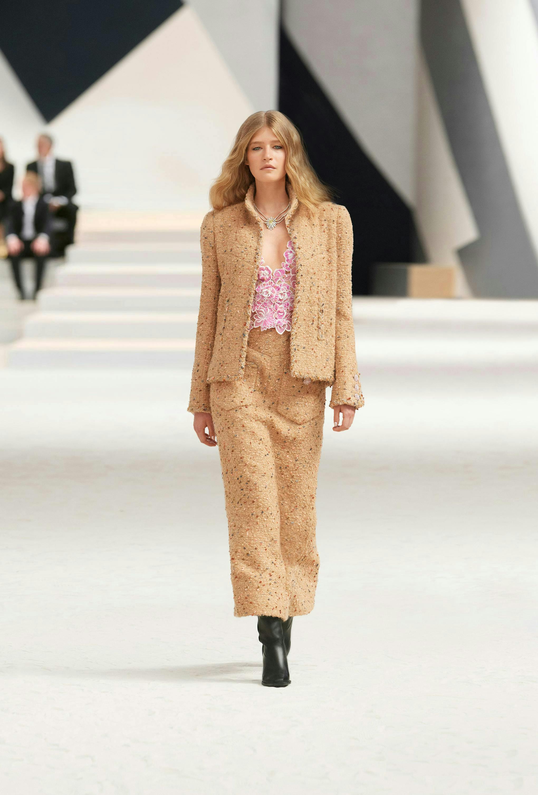 Người mẫu cho Chanel trong chiếc áo khoác vải tuýt màu nâu và quần tây.
