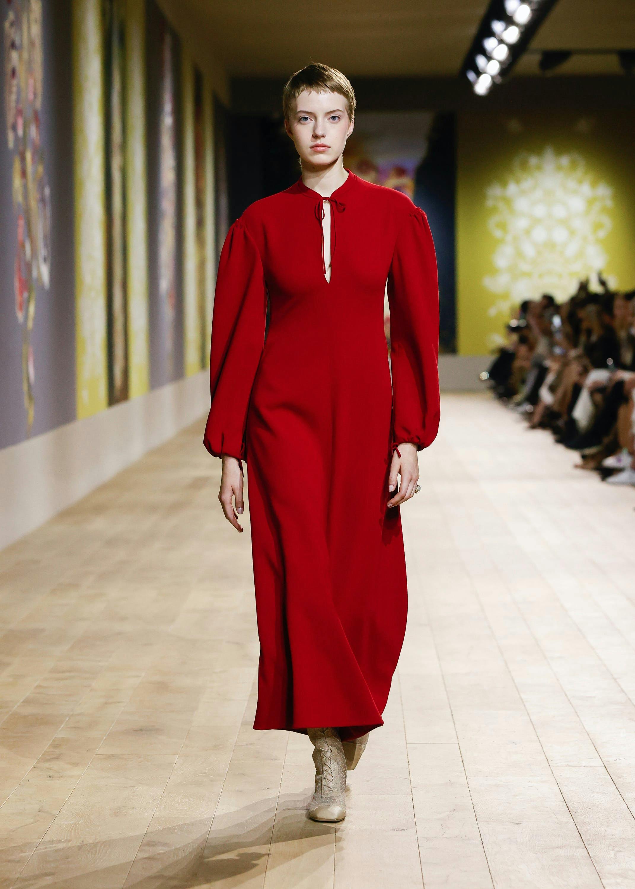 Người mẫu cho Dior trong chiếc váy đỏ rực và đôi bốt màu rám nắng.