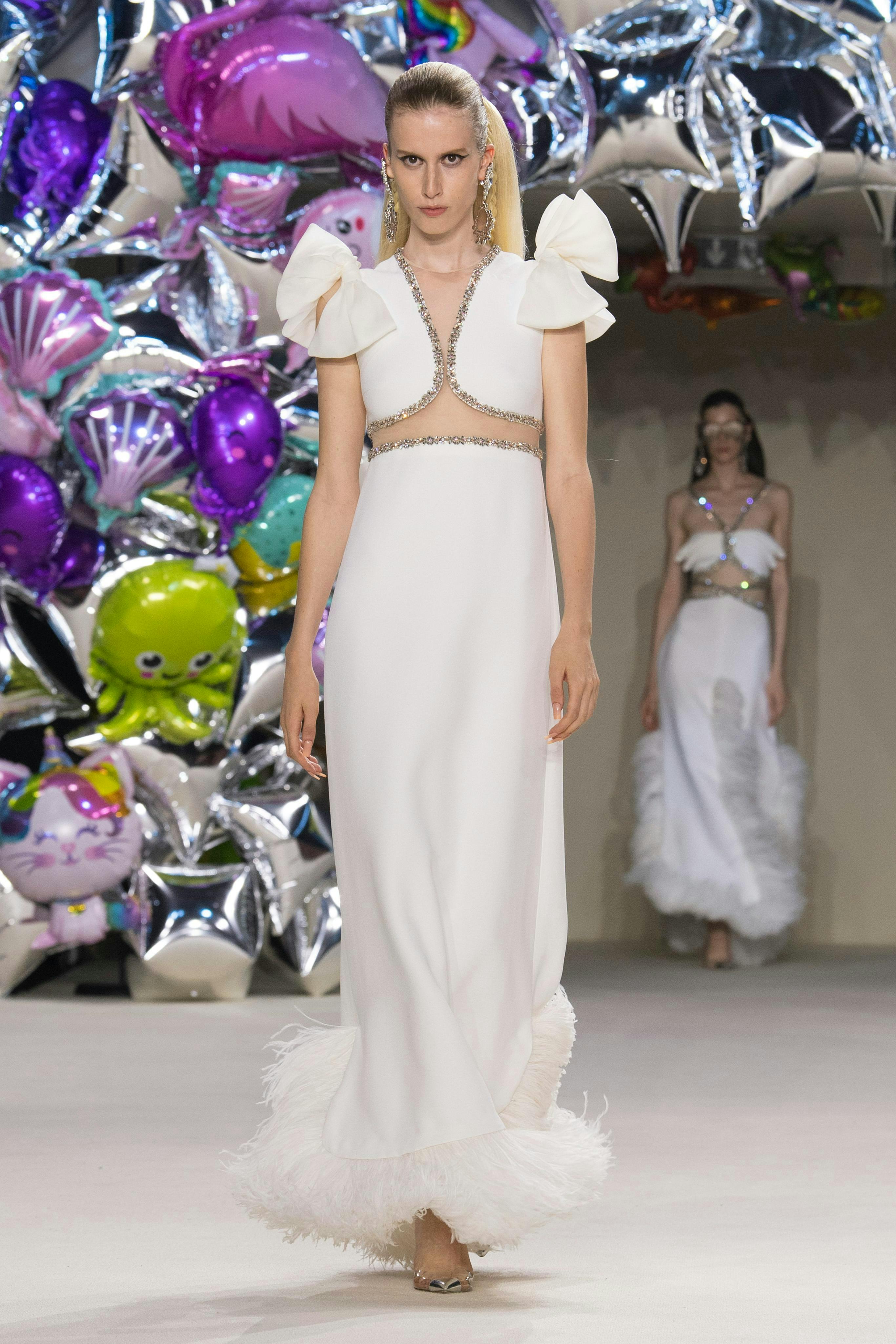 Người mẫu cho Giambattista Valli mặc áo trắng và váy dài.