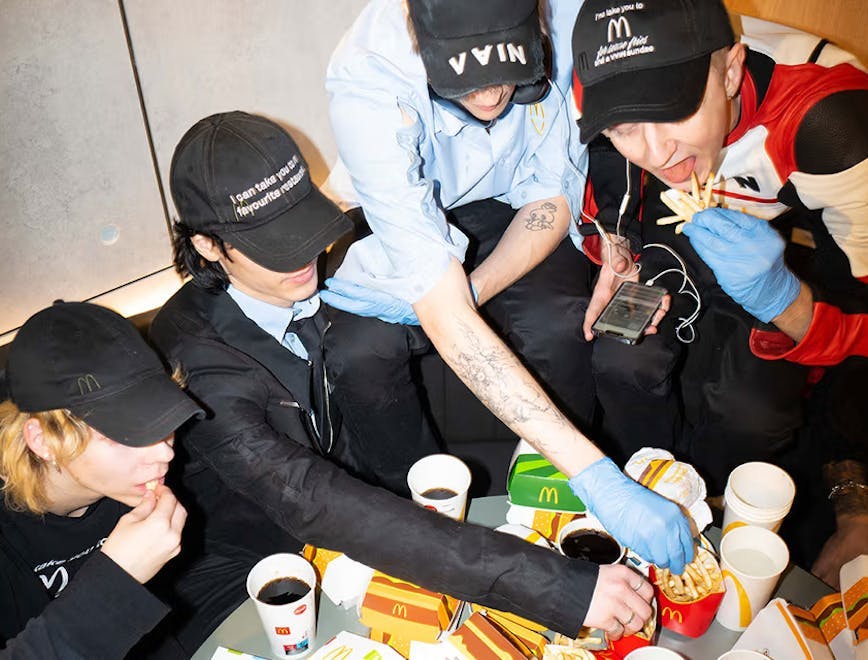 baseball cap clothing hat glove person cup disposable cup eating food face