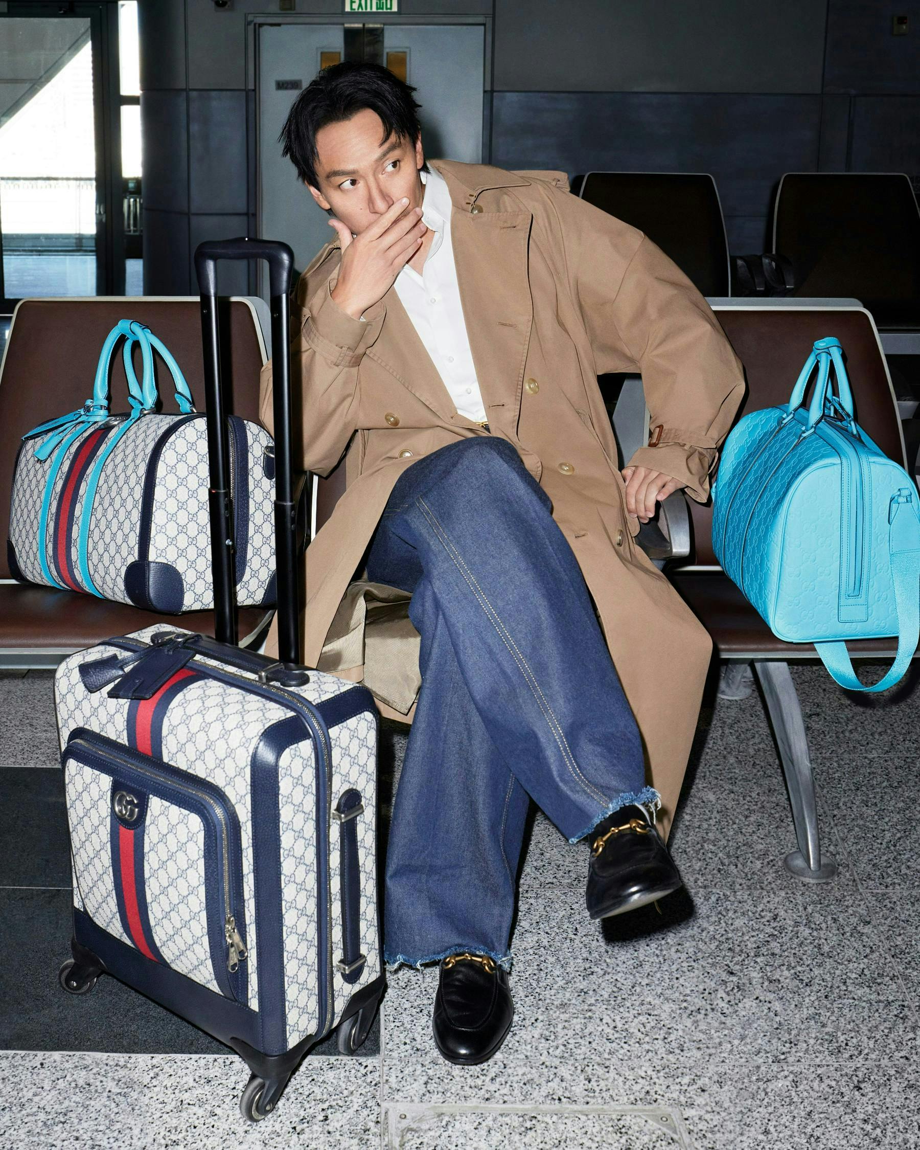 baggage bag handbag person clothing footwear shoe sitting coat jeans