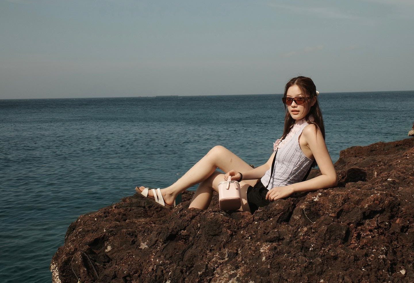 rock person sitting beachwear adult female woman nature outdoors sky